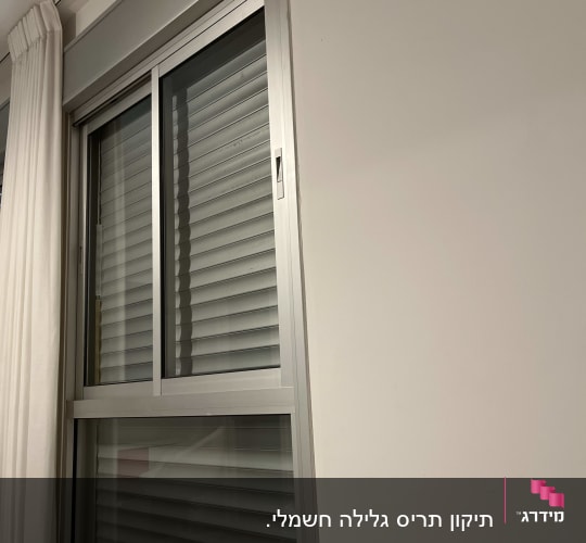 חלון עם תריסים סגורים בחדר